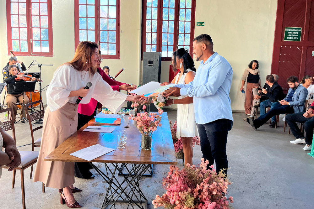 juíza coordenadora do Cejusc da comarca de Ouro Preto, Dra. Ana Paula Lobo Pereira de Freitas, faz entrega das certidões de casamento.