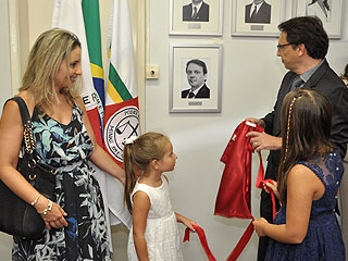 O juiz Cássio Fontenelle descerra a foto acompanhado das filhas e da esposa, juíza Luciana Fontenelle