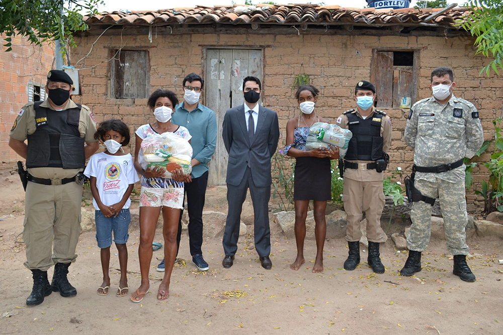 Autoridades, em frente a residência em área rural, com família beneficiada 