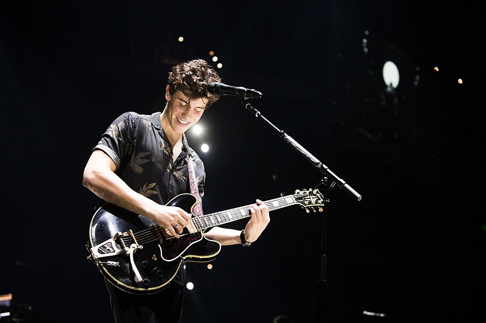 Cantor toca guitarra em show