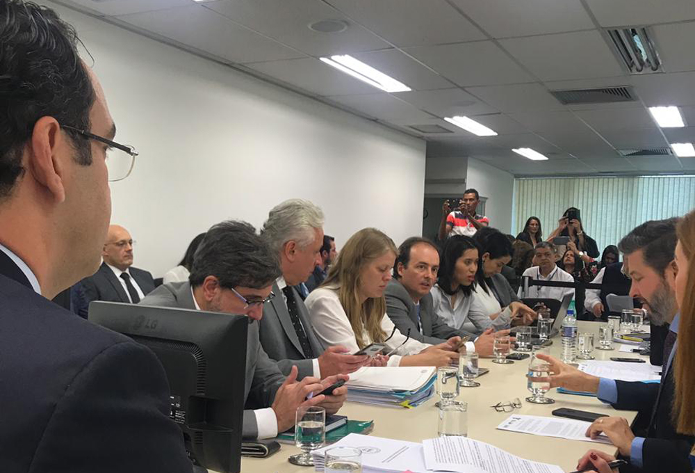 Mesa comprida com várias pessoas em volta