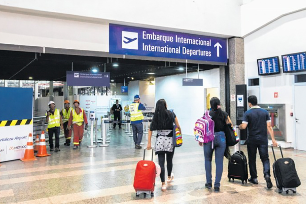 Pessoas circulando em aeroporto, na área de embarque internacional