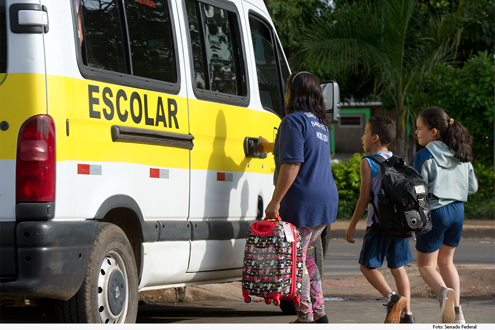 Crianças se dirigem a ônibus escolar