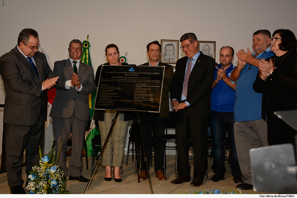 Várias pessoas descerrando uma placa