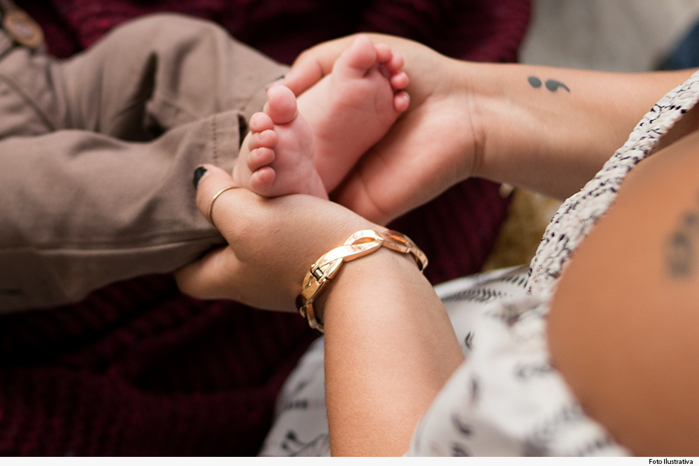 Mão de mulher segurando pé de recém-nascido