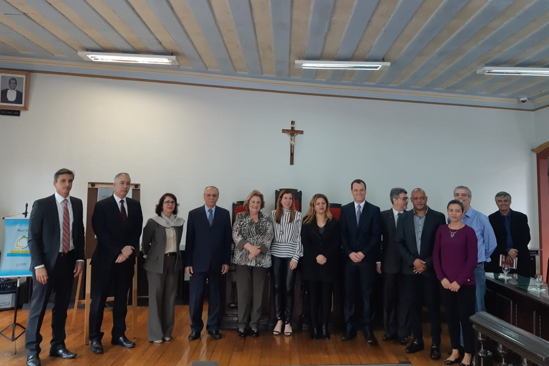 Grupo de pessoas em sala com imagem de crucifixo na parede