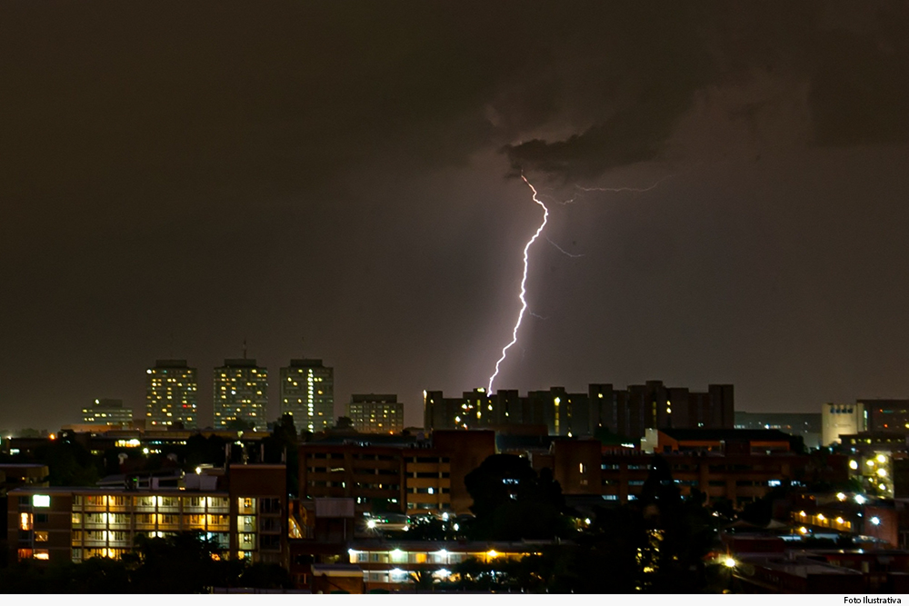 Vista noturna de céu tempestuoso sobre cidade iluminada