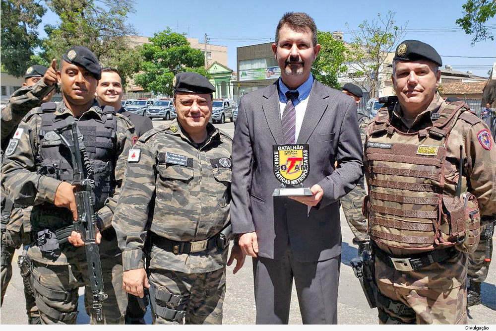 Juiz segura placa com homenagem entre policiais militares