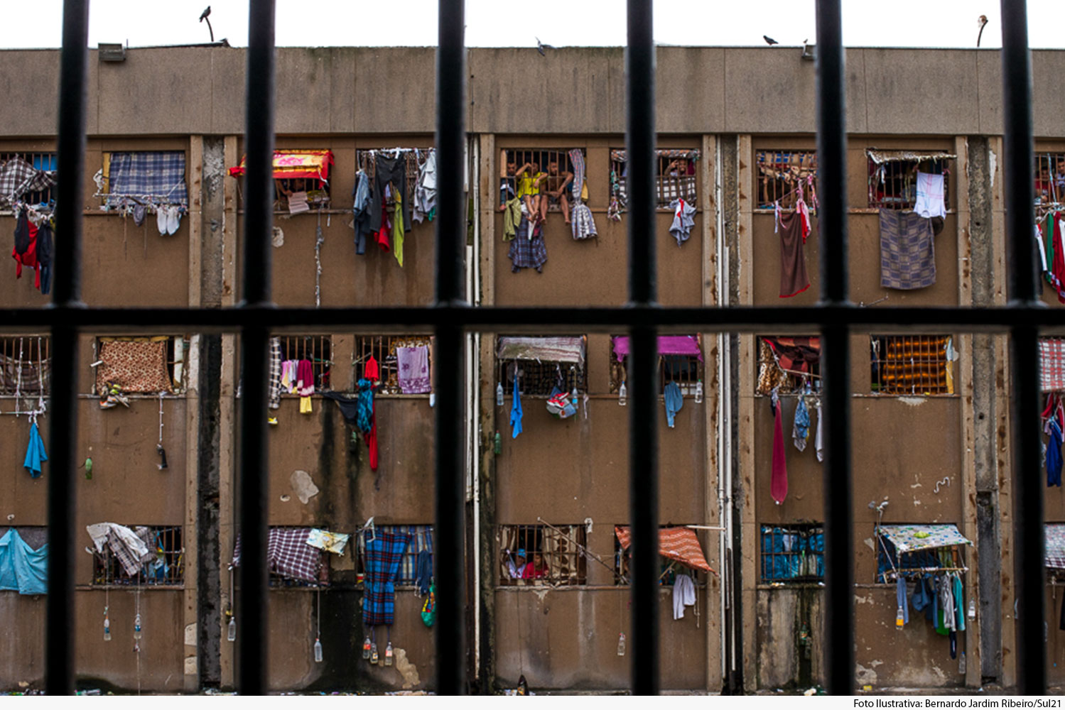 Vista de cela para interior de presídio através das grades