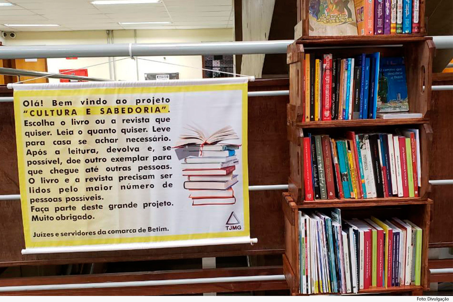 Cartaz ao lado de estante com livros