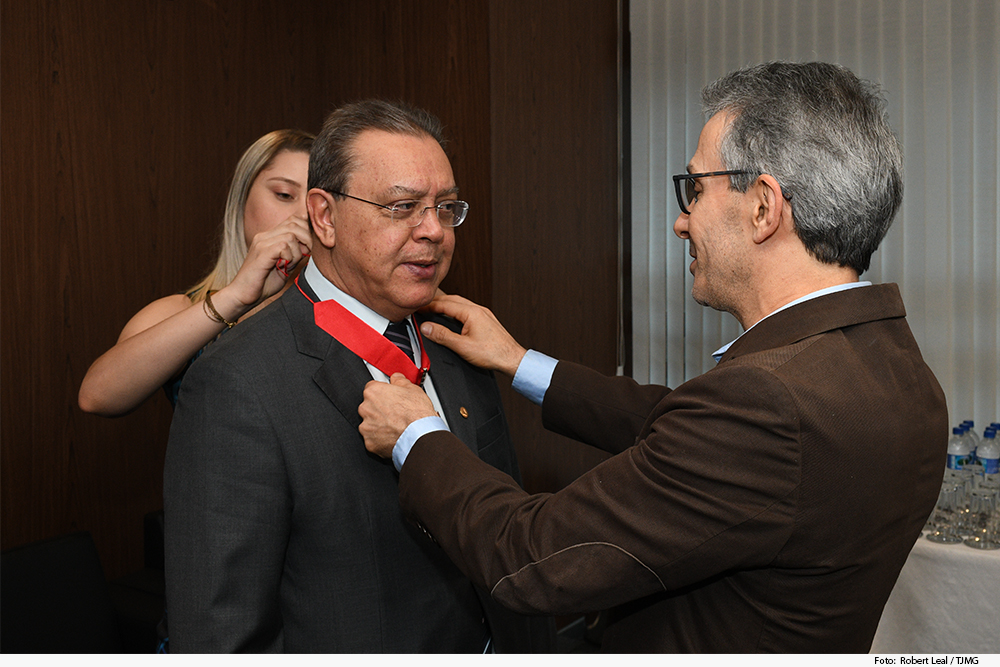 Homem entrega medalha a outro