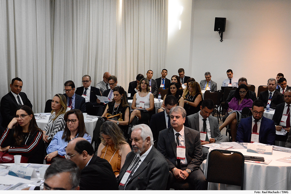 PÃºblico dividido em grupos (mesas) assiste a palestra