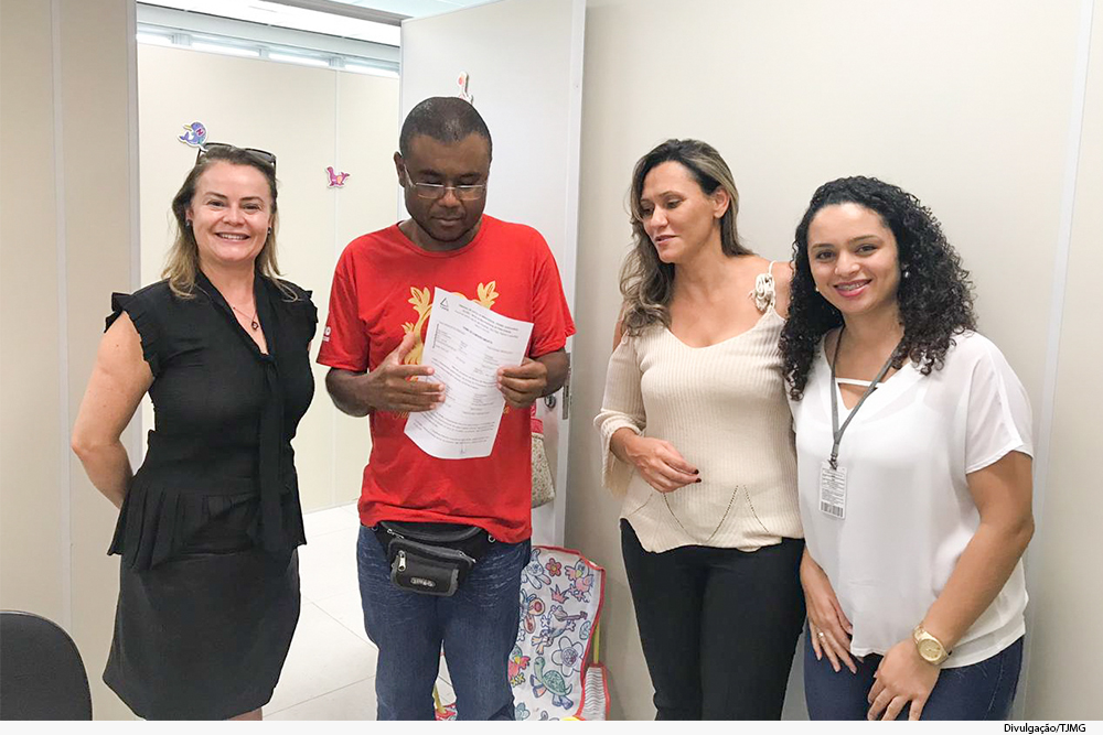 Juíza, servidores e parte com registro na mão