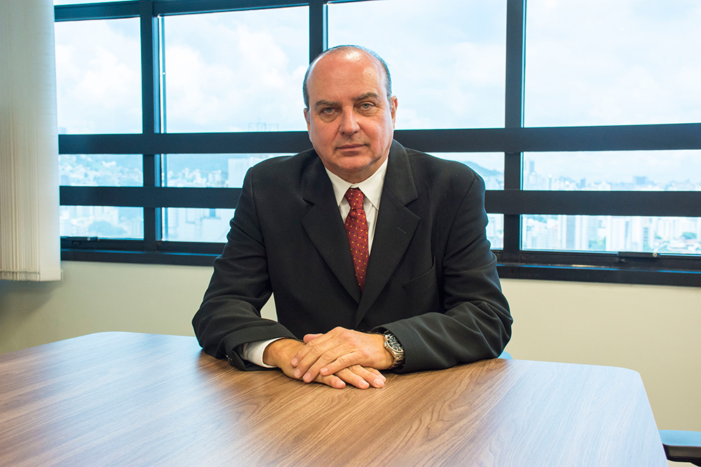 Magistrado em gabinete de trabalho, tendo janela ao fundo