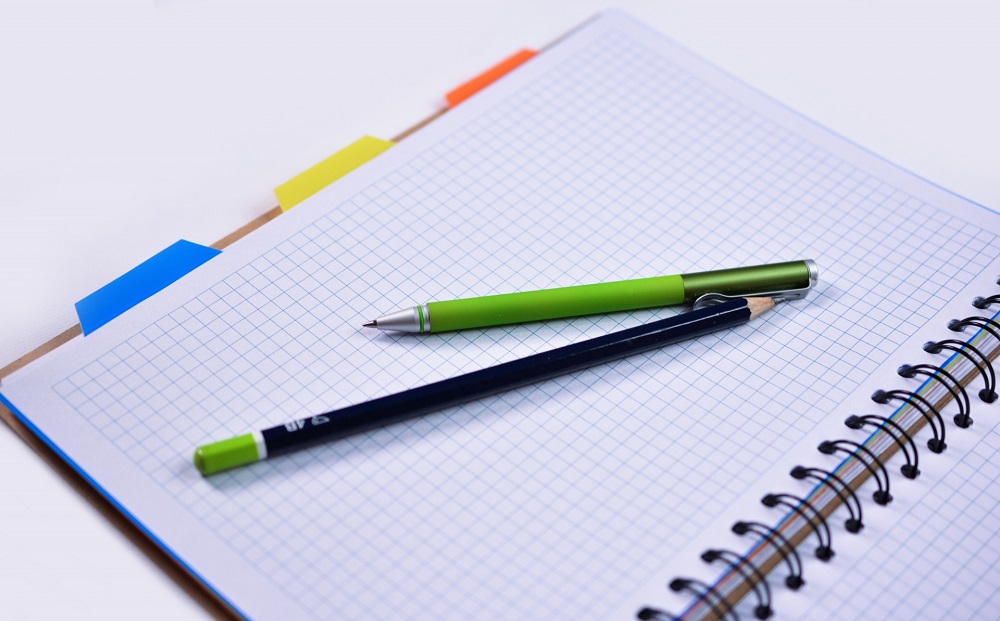Caderno quadriculado e caneta sobre mesa