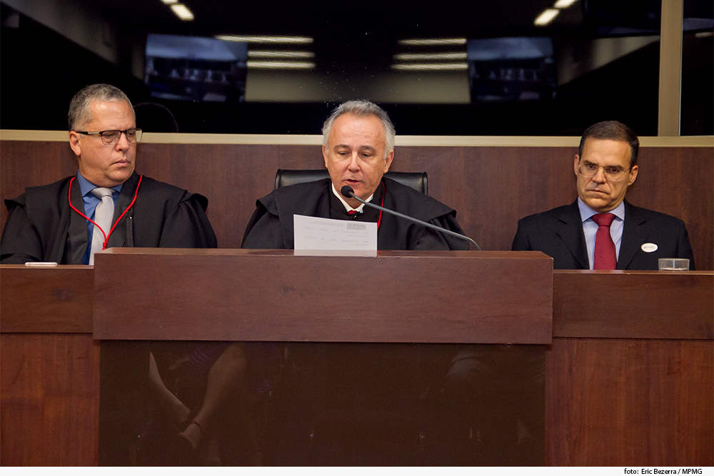 Autoridade discursa em solenidade, sentado à mesa de honra