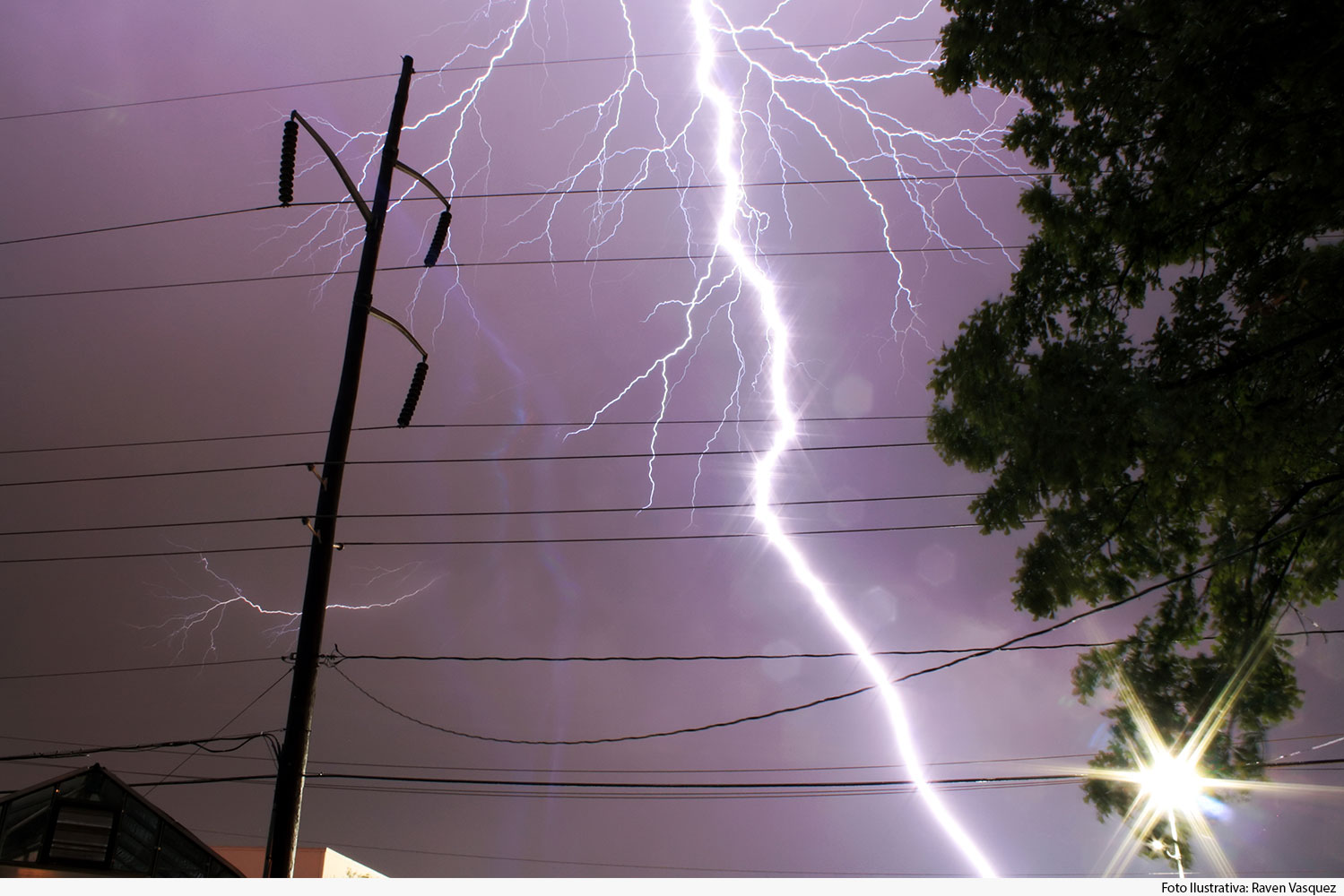 Raios em céu noturno, com poste de luz ao fundo