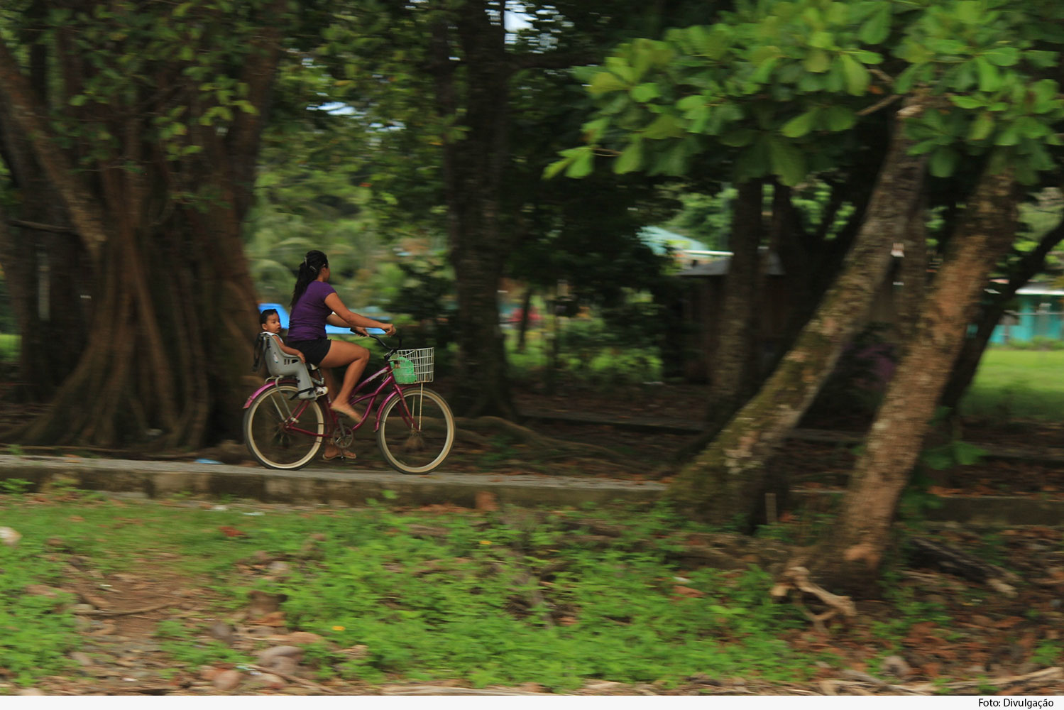 Mulher em bicicleta com criança na garupa