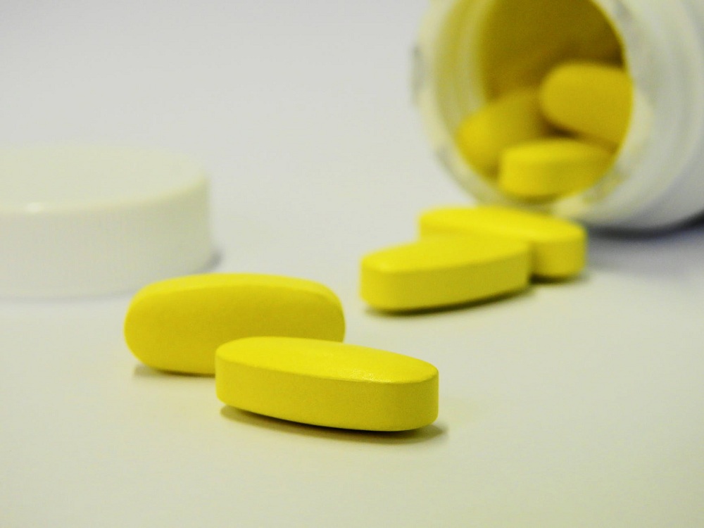 Cápsulas de remédio sobre a mesa com frasco de medicamento