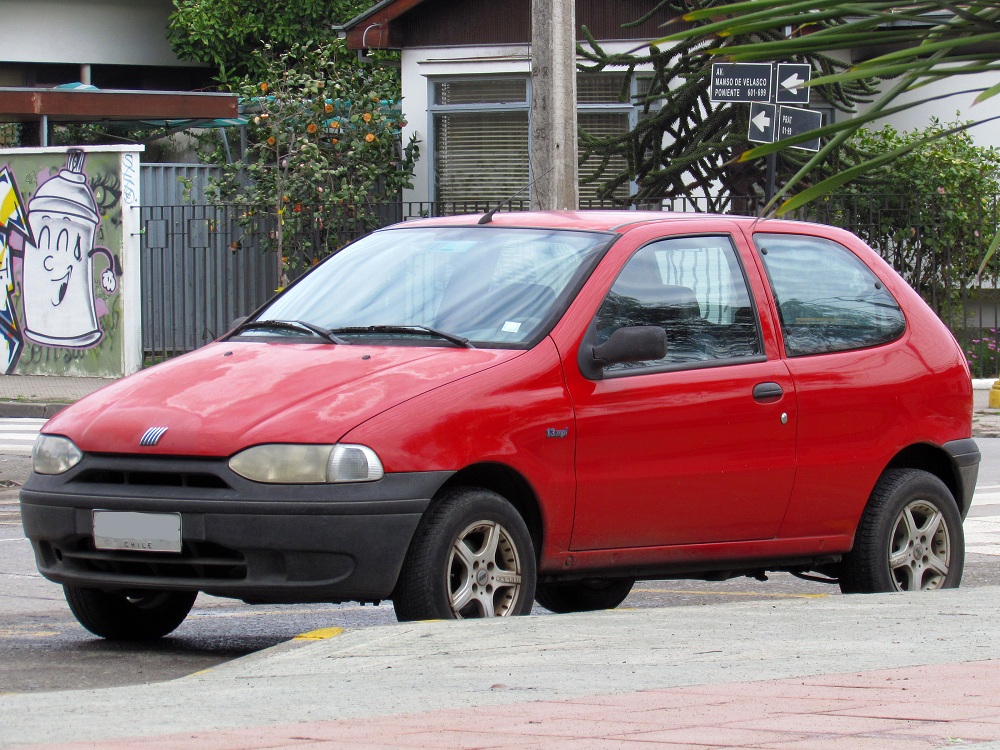 Carro Fiat Palio estacionado na rua na porta de uma casa