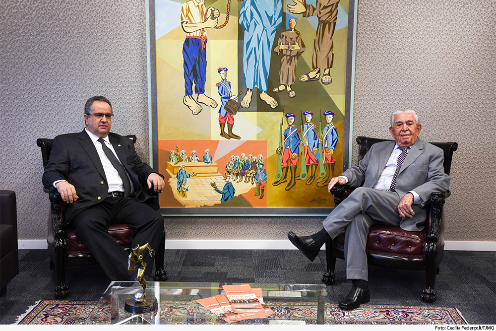 Dois magistrados sentados em gabinete da Presidência com quadro ao fundo