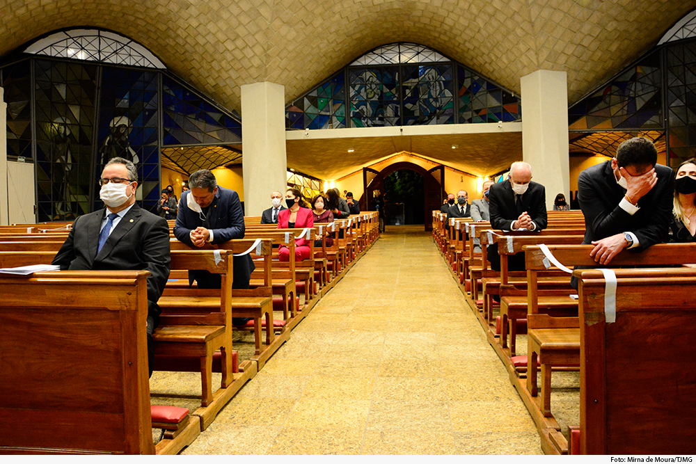 Fiéis ajoelhados em celebração de missa