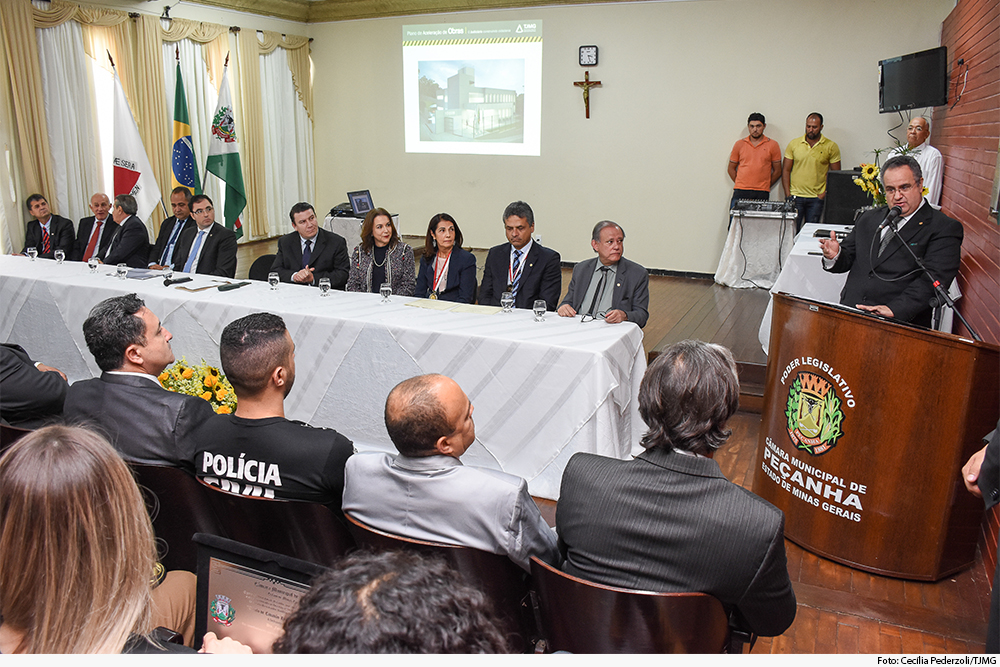 Presidente discursa em trinua diante de mesa de autoridades