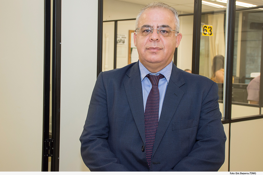 foto mostra homem de cabelos brancos, terno e óculos