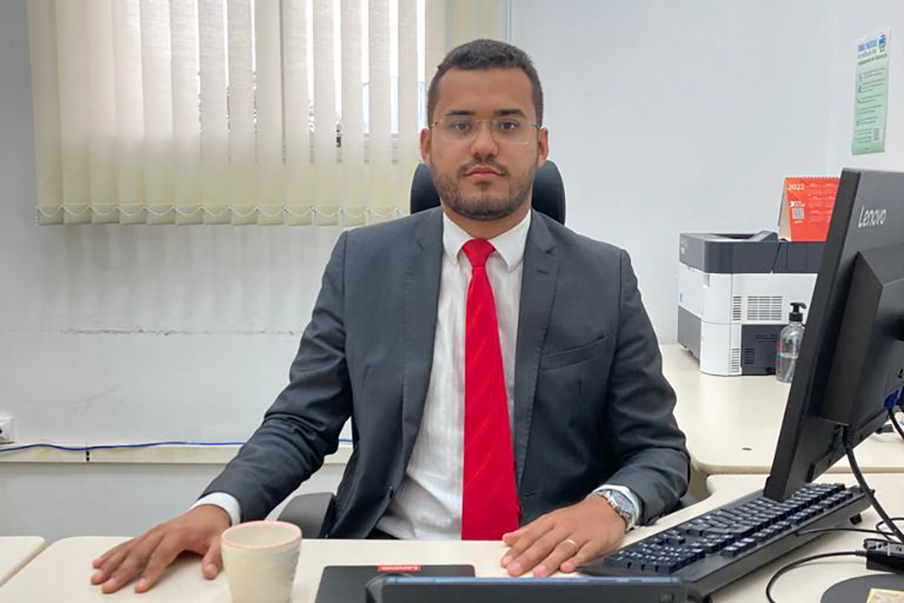 Magistrado de termo, sentado à mesa de trabalho em gabinete