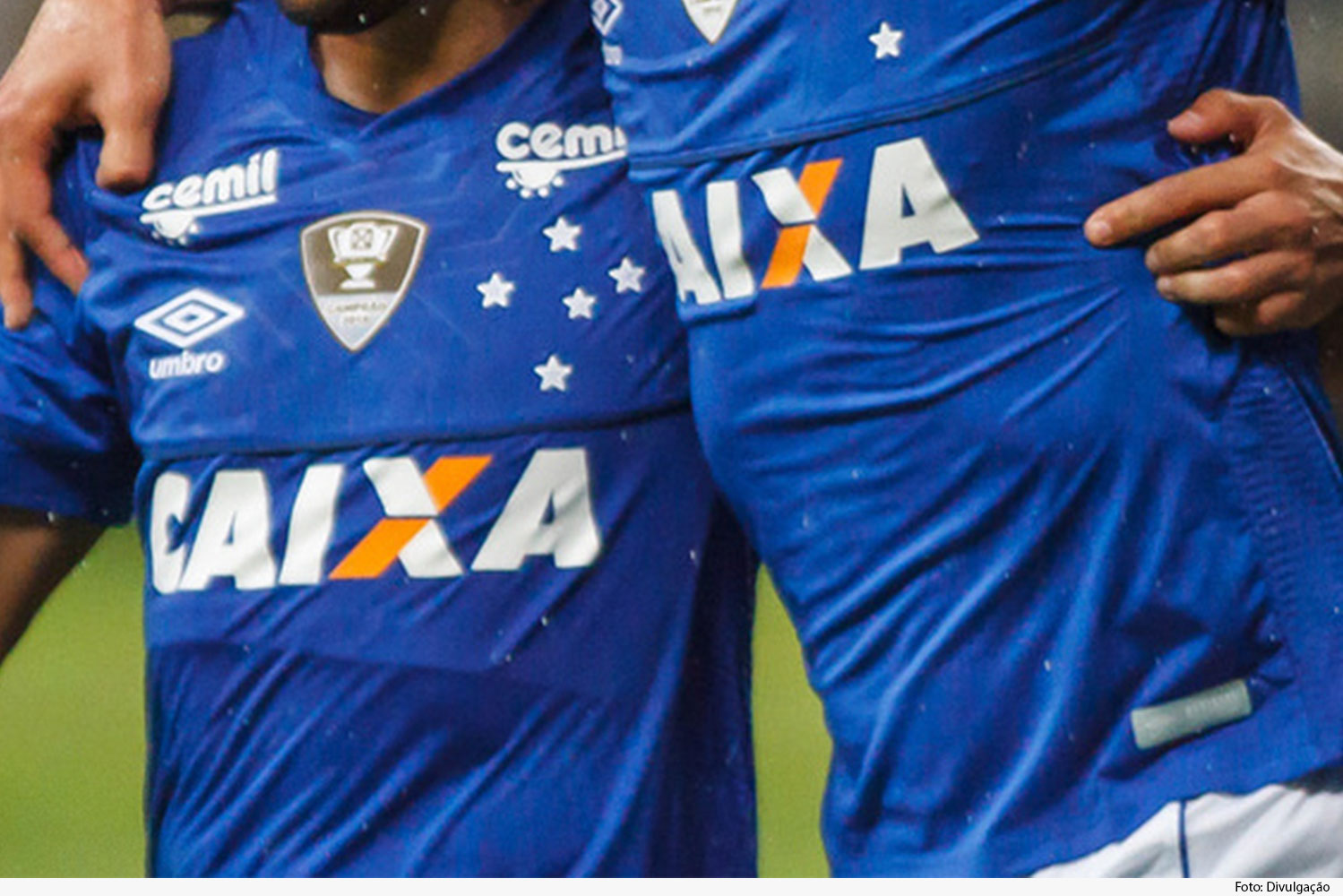 Dois jogadores abraçados, usam camisa azul do time Cruzeiro Esporte Clube