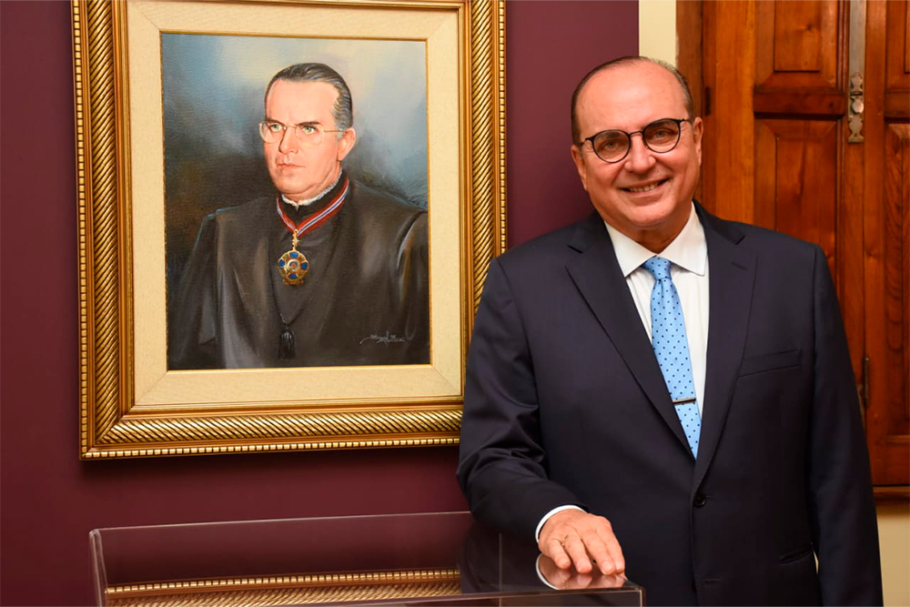 Presidente ao lado de quadro do pai, que também presidiu o TJMG