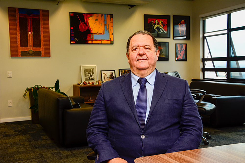 Magistrado em gabinete de trabalho, com livros ao fundo