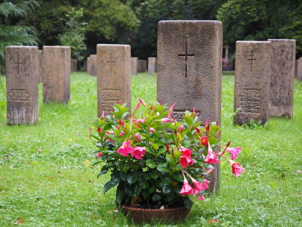 Imagem de lápide com flores em cemitério