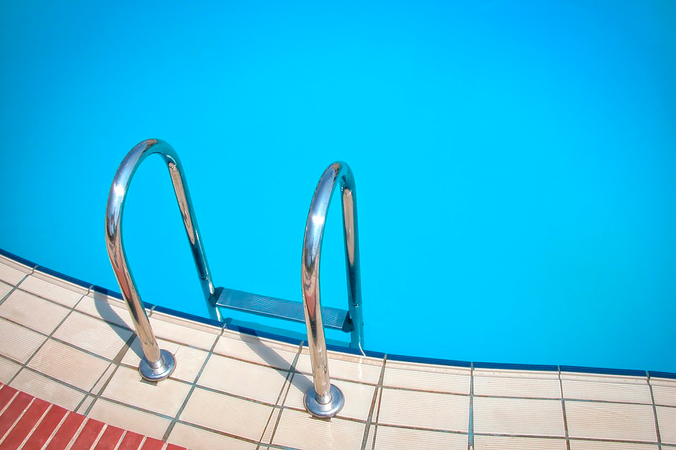 borda de piscina com escada e a piscina