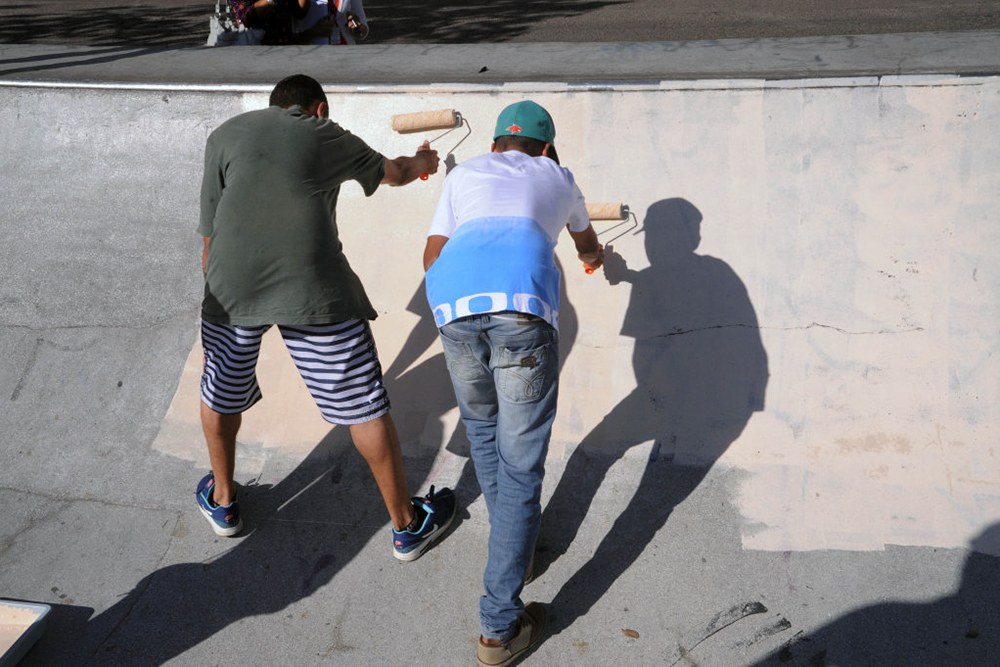 Jovens infratores pintam muro que havia sido pichado