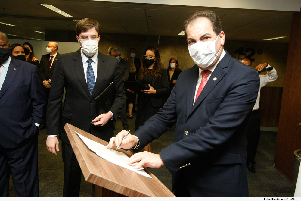 Público, de pé, acompanha assinatura de termo