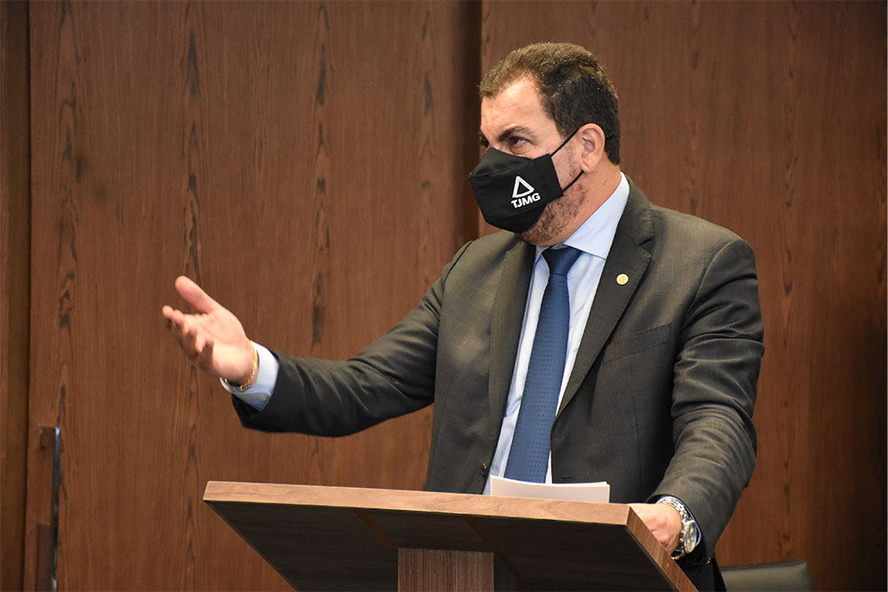 Magistrado, de terno, discursa em tribuna