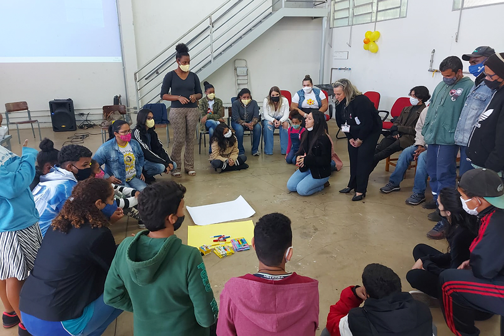 Estudantes e professores conversam em roda na sala de aula