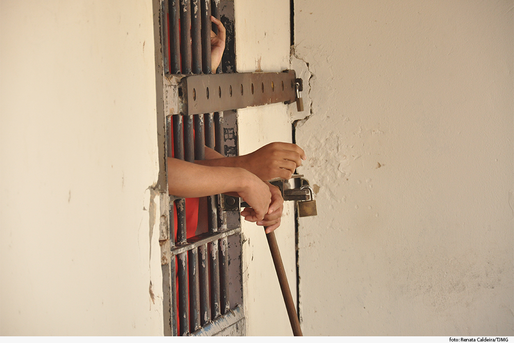 A imagem mostra uma cadeia com presos em destaque