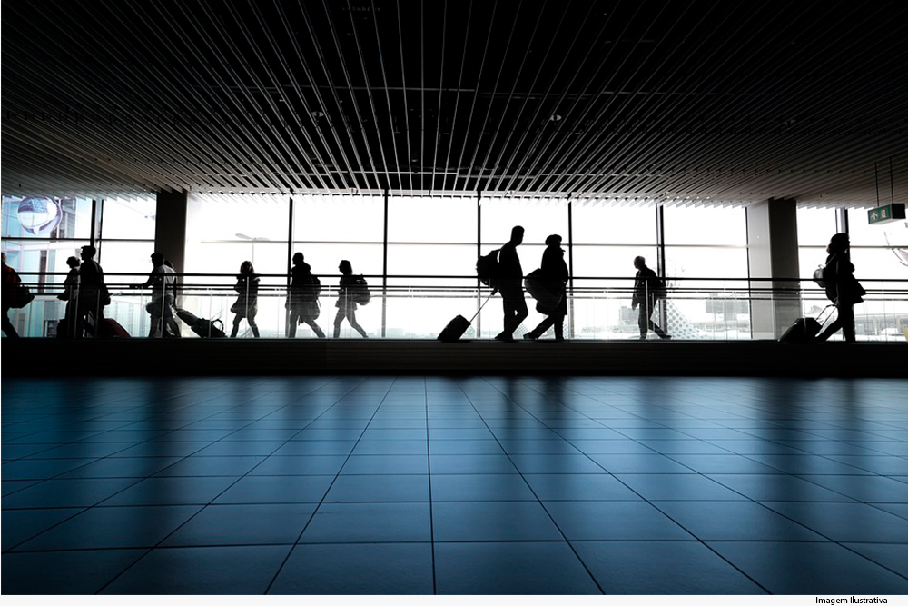 Pessoas caminham com malas em aeroporto